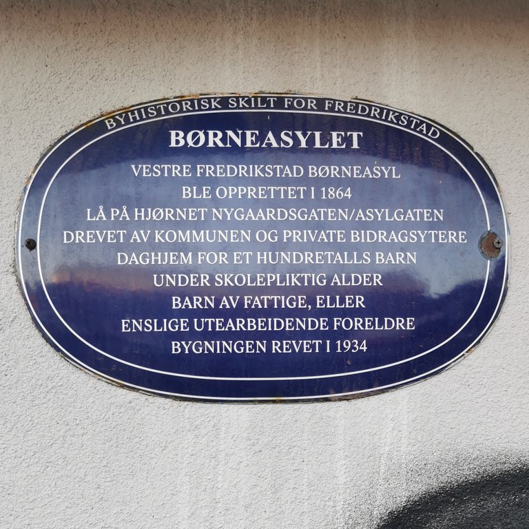 Bilde av et blått metallskilt i Fredrikstad, på det som tidligere var Børneasylet